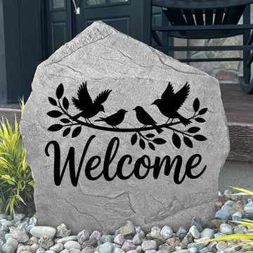 Engraved Welcome Bird Stone displayed in a landscaped garden, showcasing detailed bird artwork and a warm welcome message. This outdoor accent creates a beautiful focal point for walkways, porches, and flower beds.