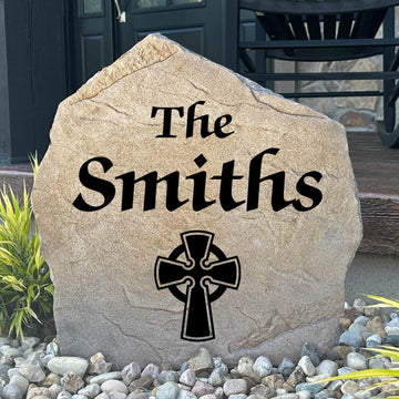 Personalized Celtic Cross Name Stone featuring custom family lettering and an elegant Celtic cross engraved directly into the stone surface. This decorative garden stone adds timeless beauty to front yards, patios, entryways, and landscape beds.