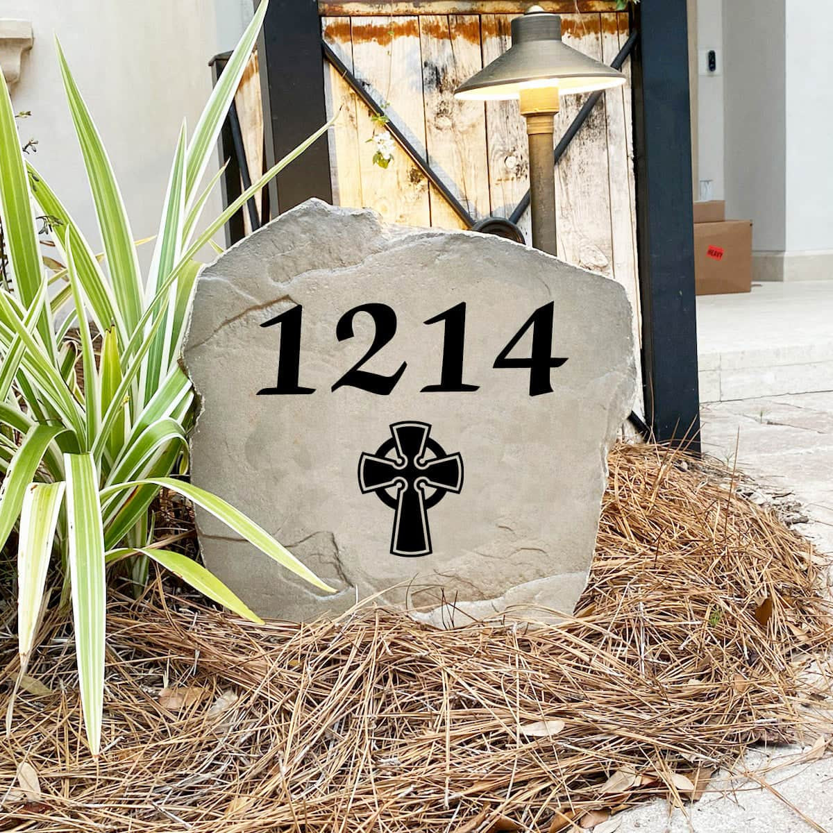 Engraved Celtic Cross Address Stone nestled among colorful flowers and greenery, combining custom house numbers with meaningful Celtic artwork. This weather-resistant address stone adds lasting beauty to walkways, patios, and landscape beds.