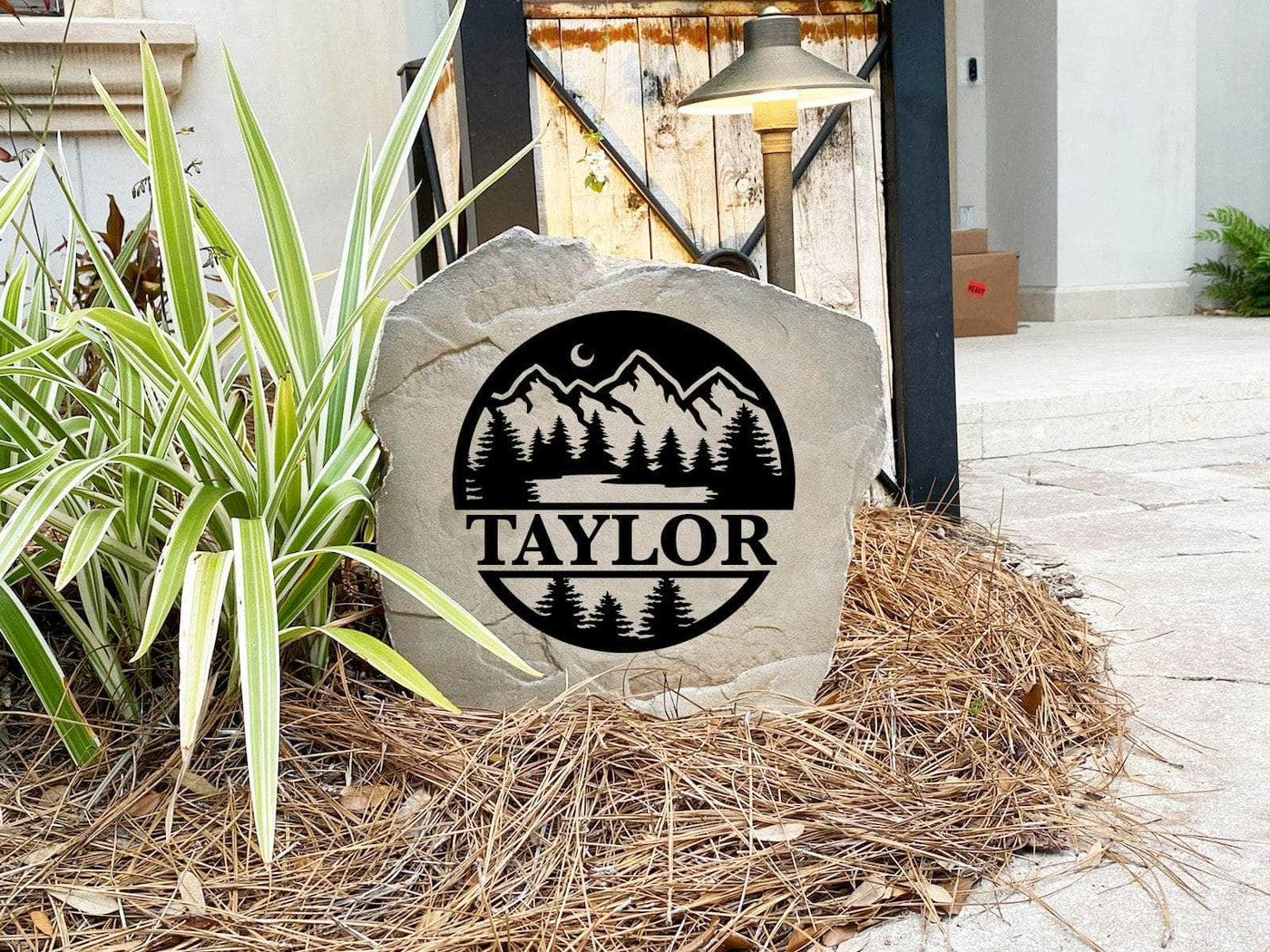 Rustic landscape stone featuring forest design and custom name for home or yard.