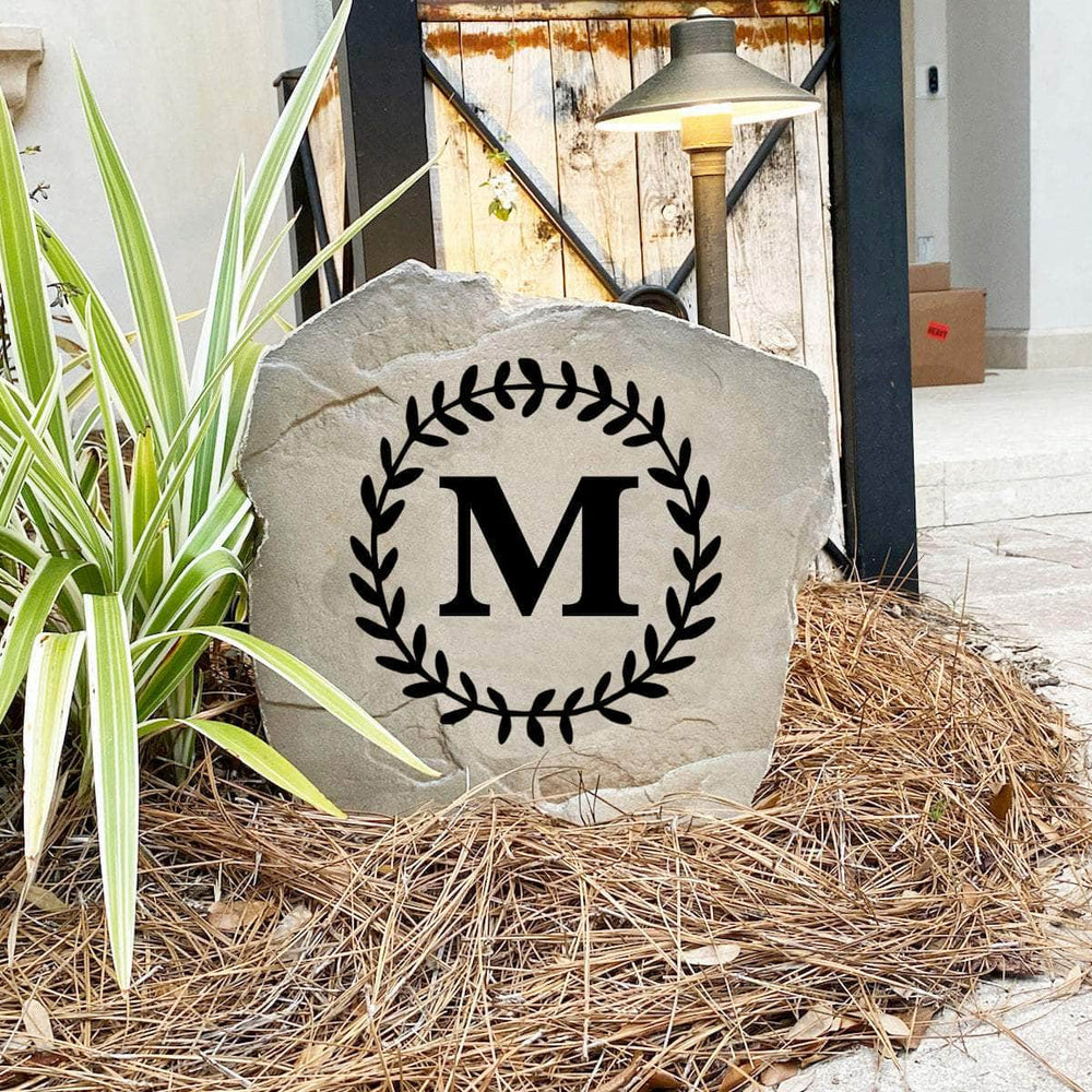 Decorative floral letter landscape stone showcasing a single engraved initial with graceful vine accents for timeless outdoor appeal.