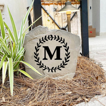 Decorative floral letter landscape stone showcasing a single engraved initial with graceful vine accents for timeless outdoor appeal.