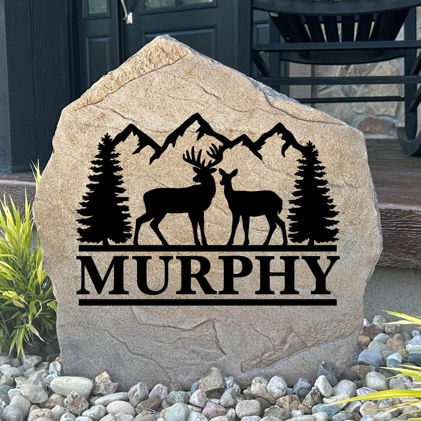 Personalized Deer Mountain Name Stone featuring custom family names and majestic deer and mountain artwork engraved directly into the stone surface. This decorative outdoor stone adds rustic charm and curb appeal to cabins, front yards, gardens, and entryways.