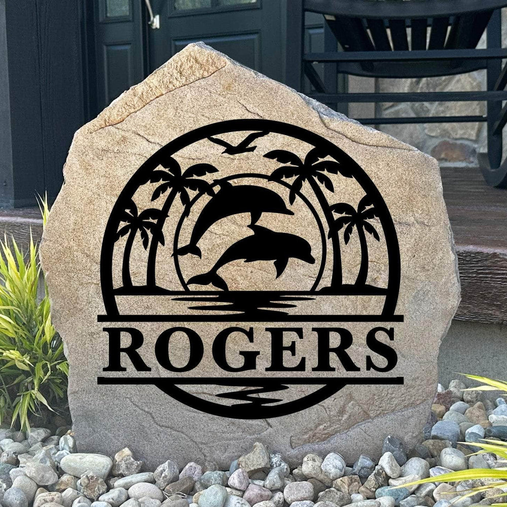 Personalized Dolphin Palms Monogram Stone featuring a custom initial with dolphin and palm tree artwork engraved directly into the stone surface. This decorative garden stone adds tropical charm and coastal curb appeal to beach houses, patios, gardens, and entryways.