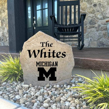 Decorative University of Michigan Name Stone featuring personalized family names permanently engraved into the stone surface alongside the official Wolverines logo. Perfect for gardens, patios, and entryways, this outdoor accent celebrates Michigan pride.