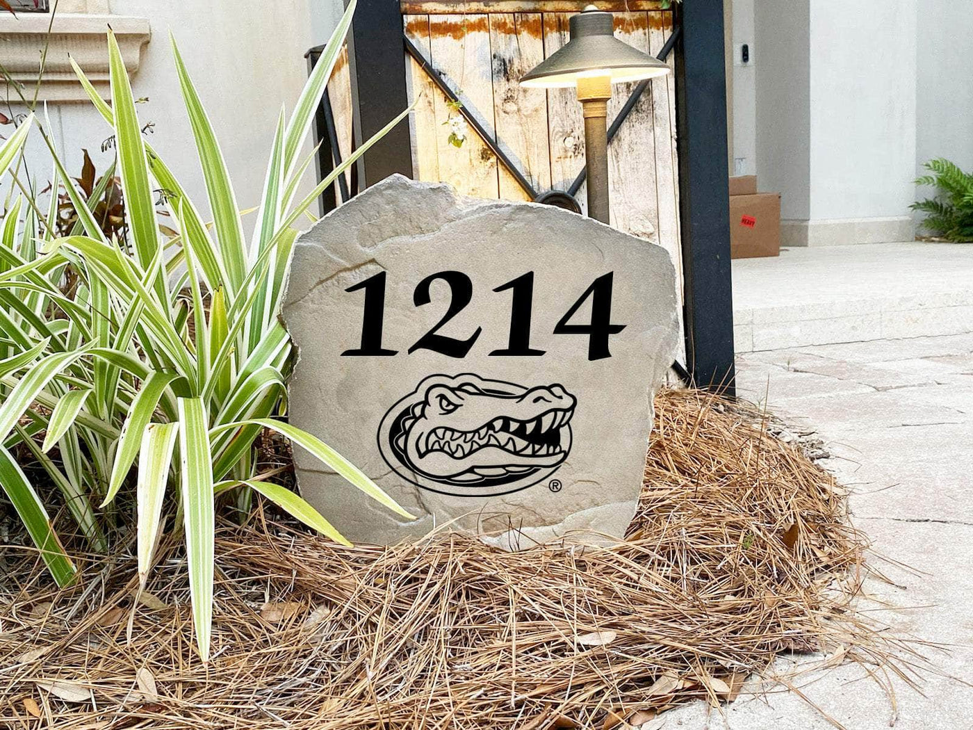 Outdoor landscaping stone with engraved Florida Gators house number design.