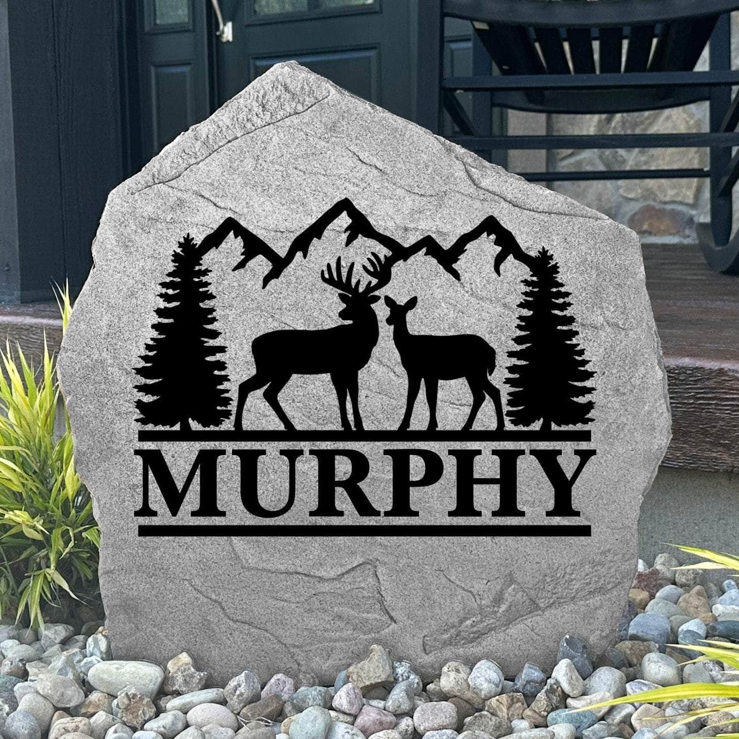 Personalized Deer Mountain Name Stone featuring custom family names and majestic deer and mountain artwork engraved directly into the stone surface. This decorative outdoor stone adds rustic charm and curb appeal to cabins, front yards, gardens, and entryways.