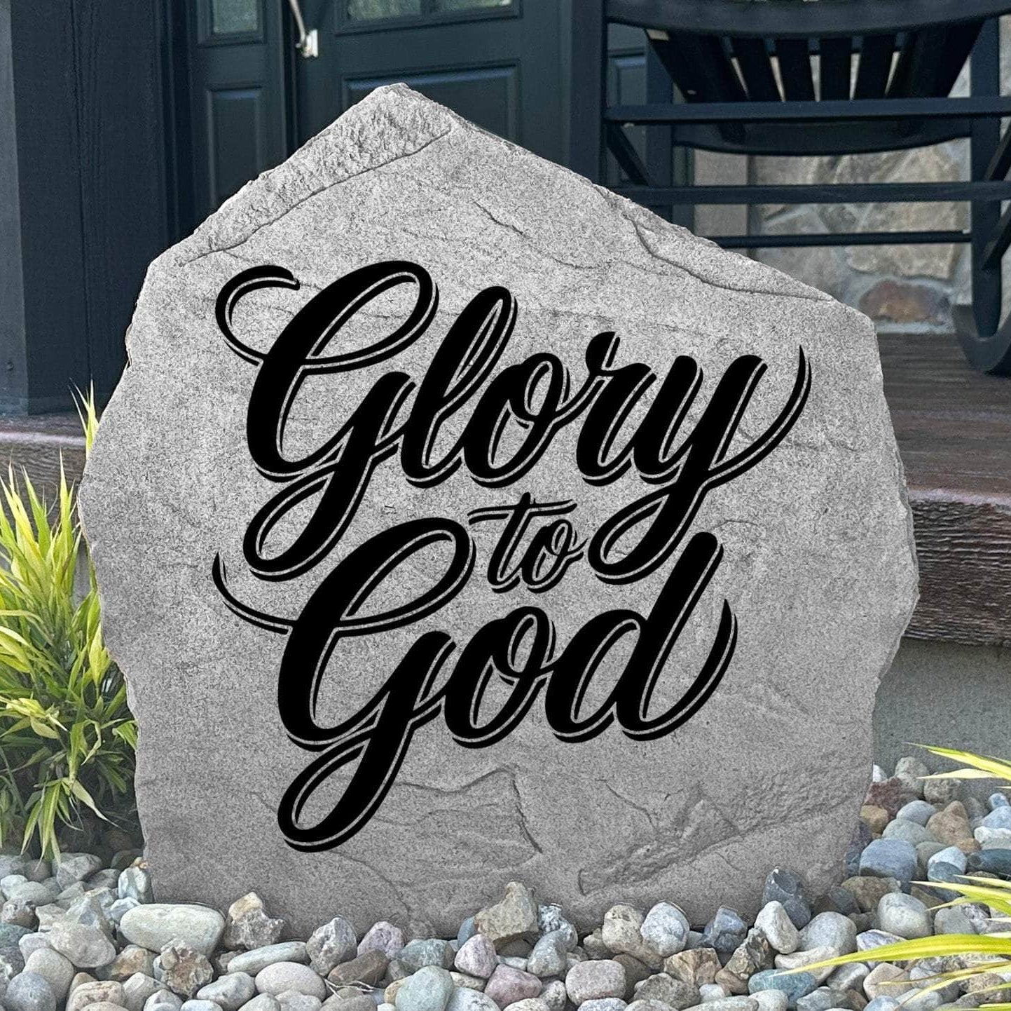 Glory To God Stone displayed in a landscaped flower bed, showcasing elegant engraving and timeless craftsmanship. This decorative outdoor stone creates a meaningful focal point for gardens and walkways.