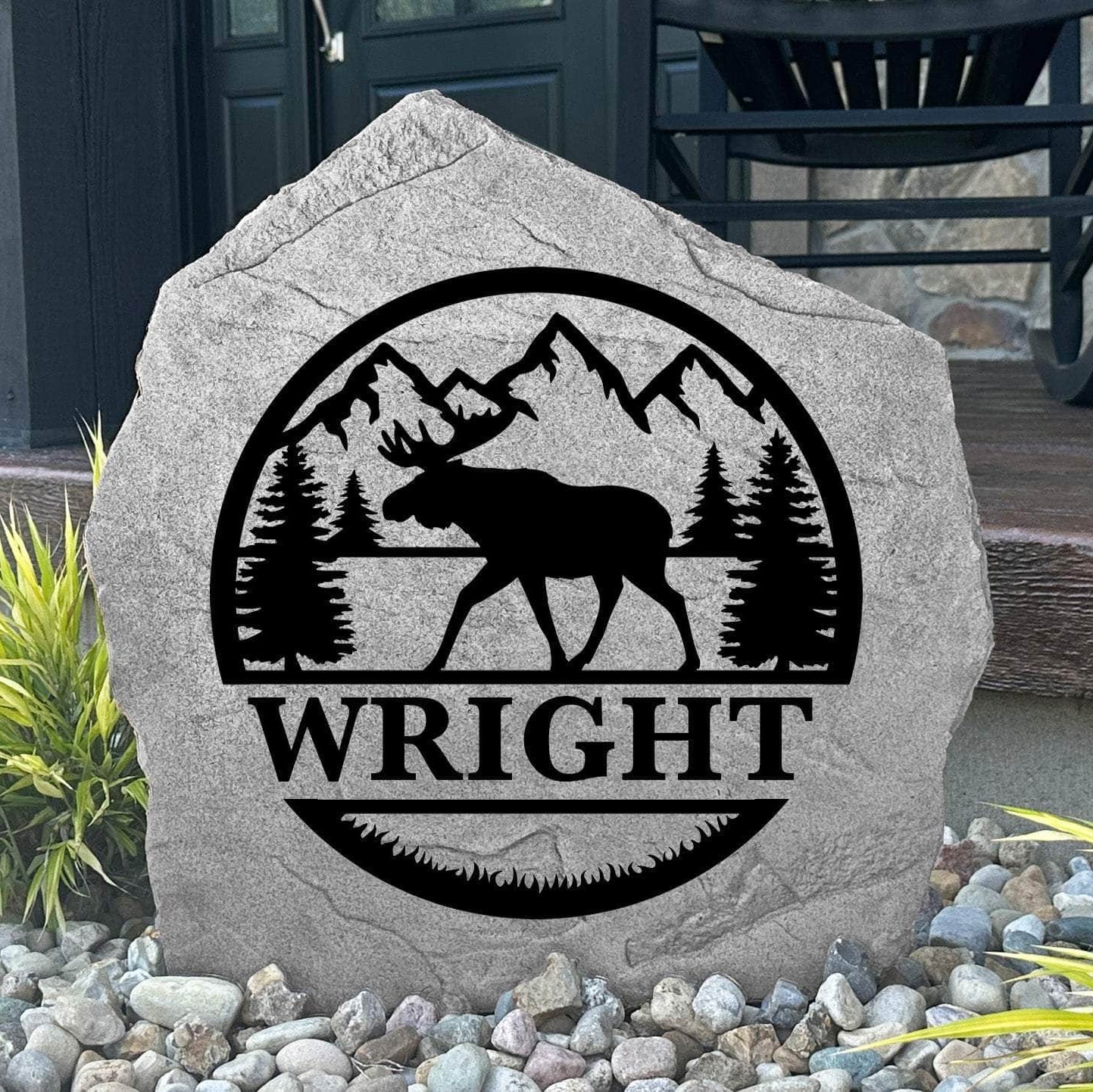 Custom Moose Monogram Stone displayed in a landscaped flower bed, showcasing personalized engraving and wildlife-inspired artwork. This engraved outdoor stone creates a beautiful focal point for cabins, gardens, and walkways.