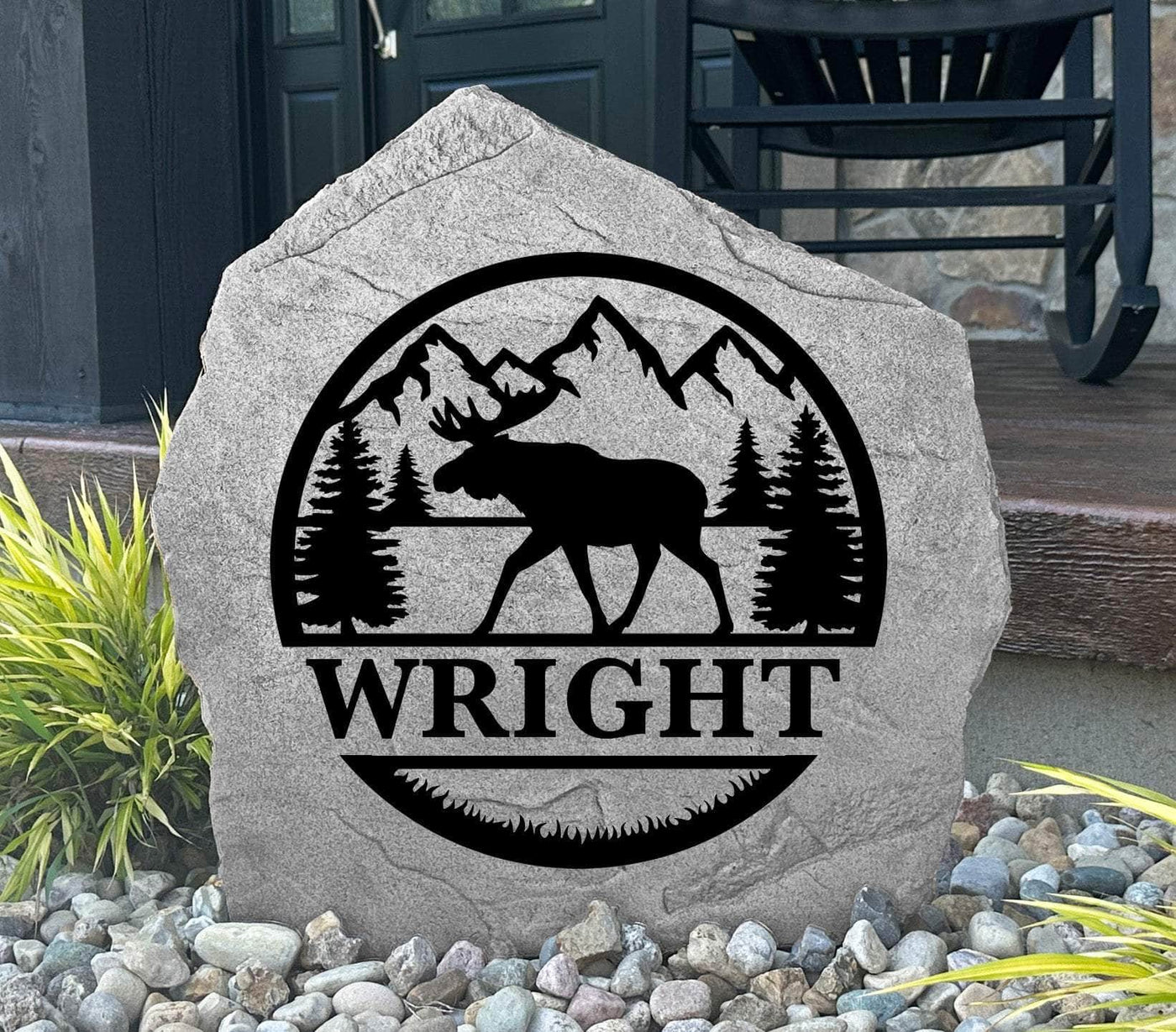 Custom engraved moose-themed garden stone with monogram and natural mountain background.
