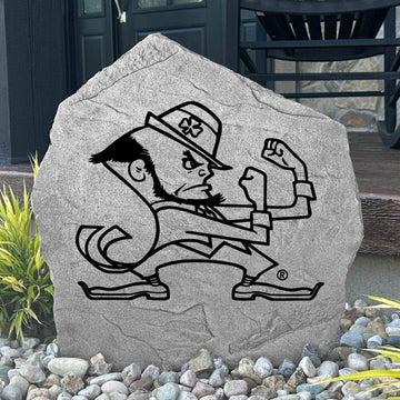 Custom Notre Dame Leprechaun Stone displayed in a landscaped flower bed, showcasing officially licensed Fighting Irish Leprechaun artwork with permanent engraving. This decorative outdoor stone creates a striking focal point for alumni homes and Notre Dame fans.