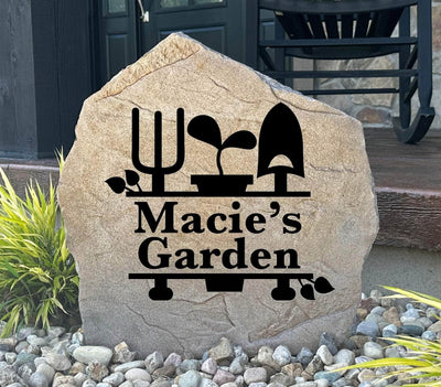Garden monogram name stone with engraved tools and plant design.