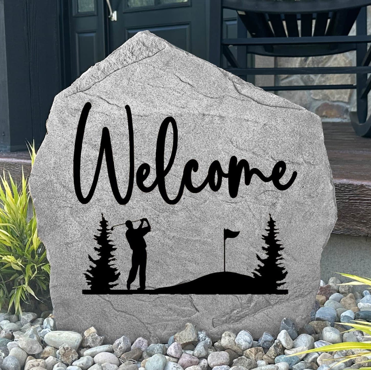 Custom Welcome Golf Stone displayed in a landscaped flower bed, showcasing detailed golf artwork and a welcoming design. This engraved outdoor stone creates a beautiful focal point for walkways and home entrances.