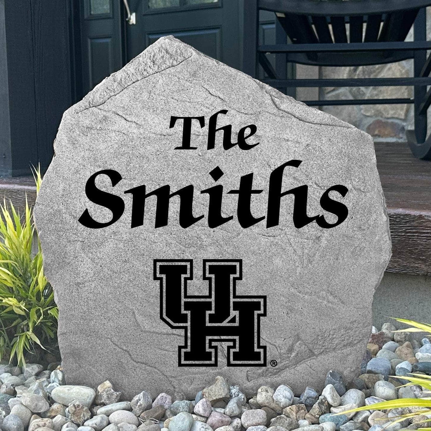 Custom University of Houston Name Stone displayed in a landscaped flower bed, showcasing personalized family lettering and officially licensed Houston Cougars artwork. This engraved outdoor stone creates a beautiful focal point for alumni homes and Cougars fans.