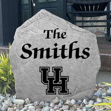 Custom University of Houston Name Stone displayed in a landscaped flower bed, showcasing personalized family lettering and officially licensed Houston Cougars artwork. This engraved outdoor stone creates a beautiful focal point for alumni homes and Cougars fans.