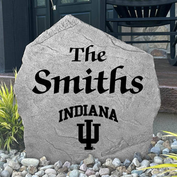 Custom Indiana University Name Stone displayed in a landscaped flower bed, showcasing personalized family lettering and officially licensed Indiana Hoosiers artwork. This decorative outdoor stone creates a beautiful focal point for alumni homes and Hoosiers fans.