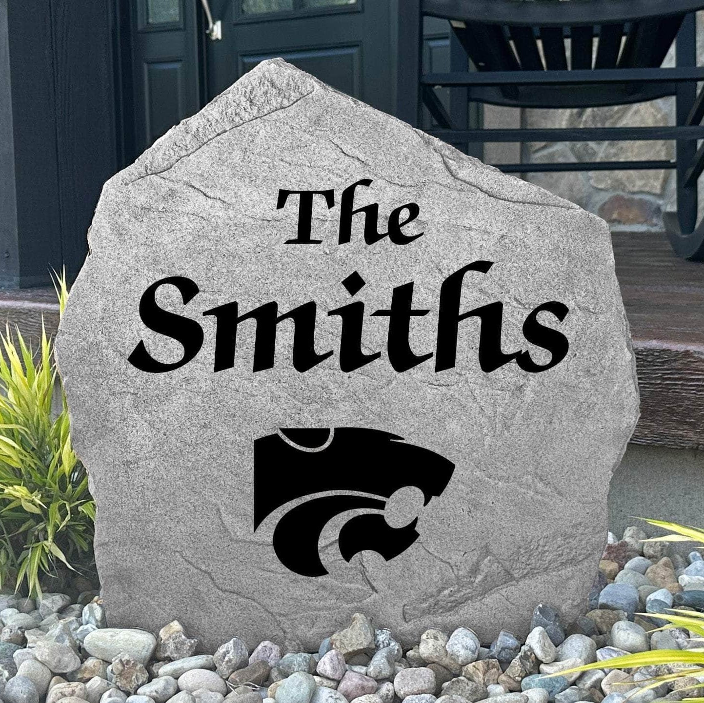 Custom Kansas State University Name Stone displayed in a landscaped flower bed, showcasing personalized family lettering and officially licensed Kansas State Wildcats artwork. This decorative outdoor stone creates a beautiful focal point for alumni homes and Wildcats fans.