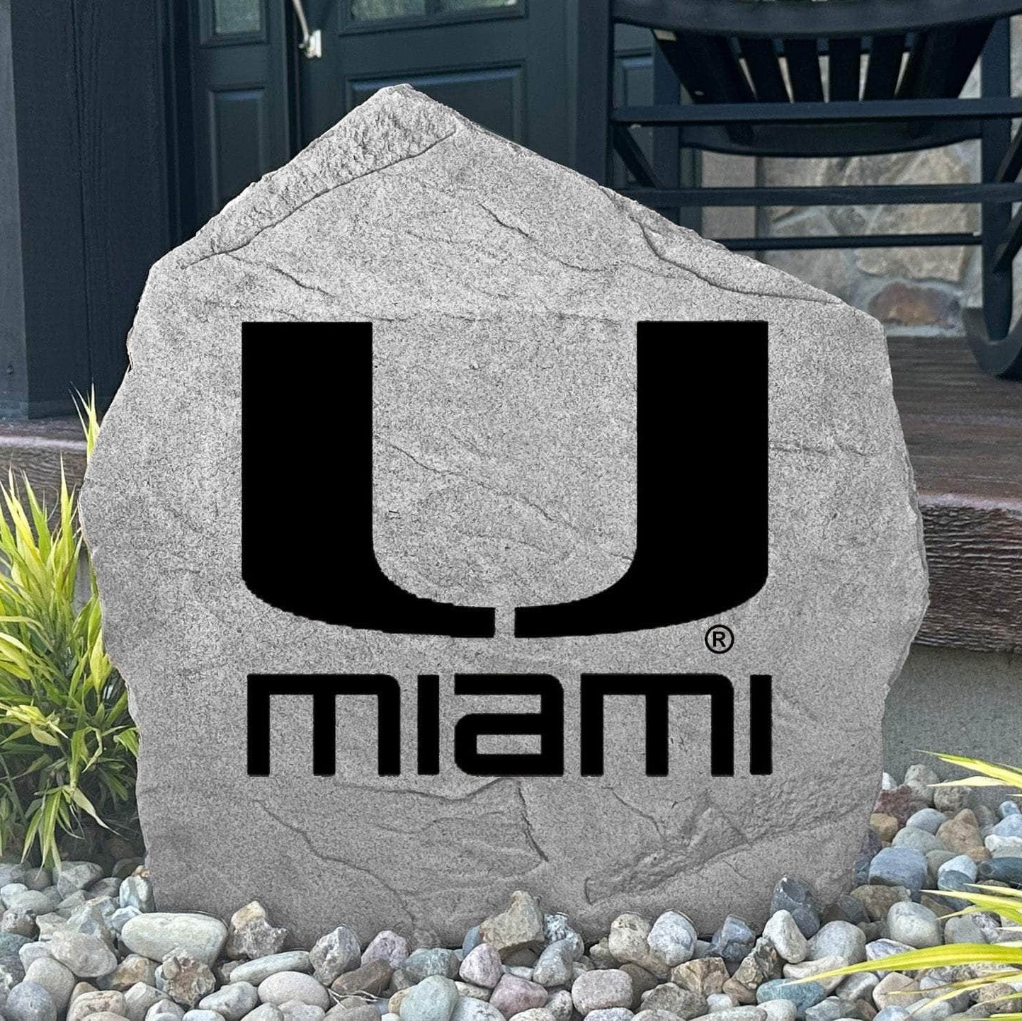 Custom Miami Hurricanes Logo Stone displayed in a landscaped flower bed, showcasing officially licensed team artwork permanently engraved into the stone. This outdoor accent creates a beautiful focal point for alumni homes and devoted Hurricanes fans.