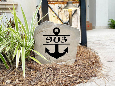 Engraved outdoor rock featuring anchor design and house address