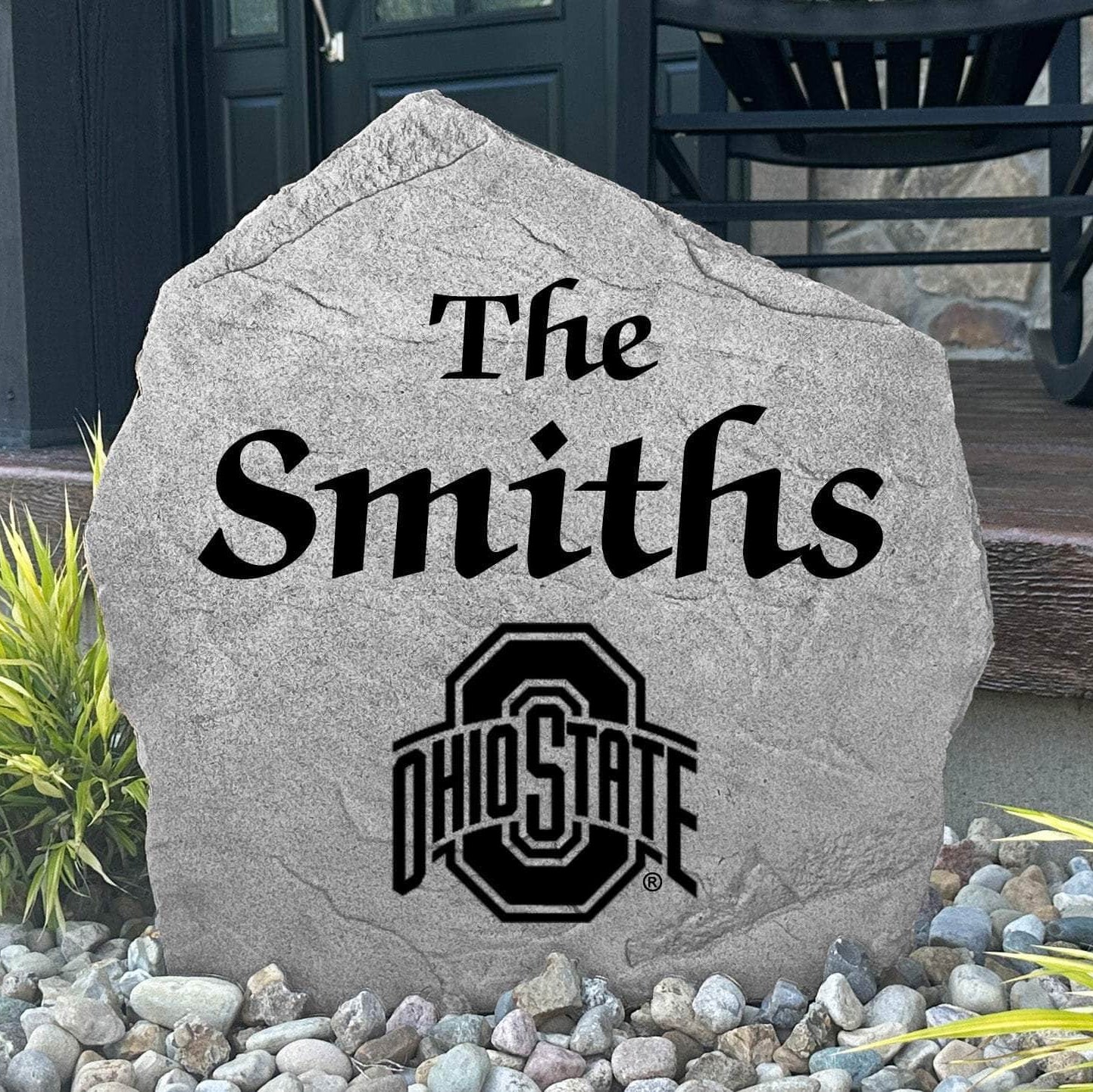 Custom Ohio State University Name Stone displayed in a landscaped flower bed, showcasing personalized family lettering and officially licensed Ohio State Buckeyes artwork. This decorative outdoor stone creates a beautiful focal point for alumni homes and Buckeyes fans.