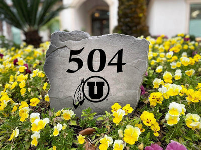 Collegiate University of Utah yard rock displaying address and logo.