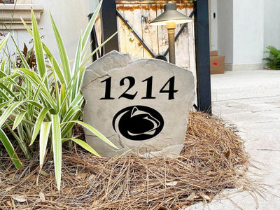Outdoor landscaping stone with Penn State sports logo and address