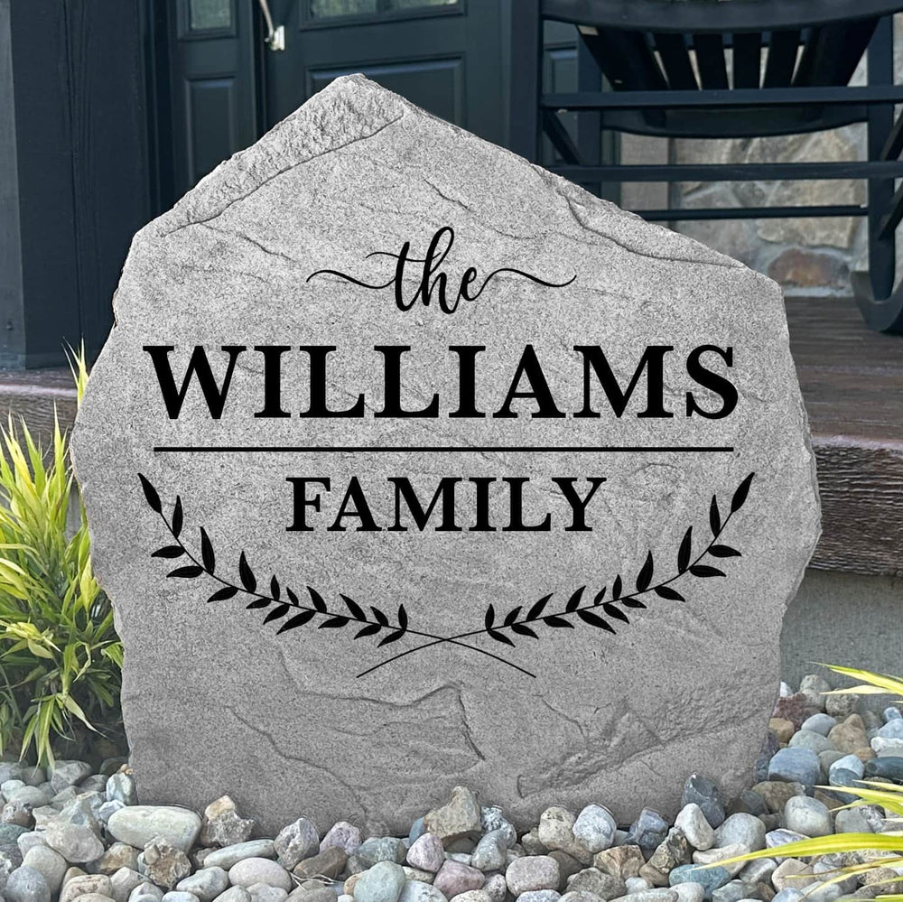 Custom Family Name Leaf Stone displayed in a landscaped garden, showcasing personalized engraving and nature-inspired leaf details. This engraved outdoor sign creates a beautiful focal point for walkways and home entrances.