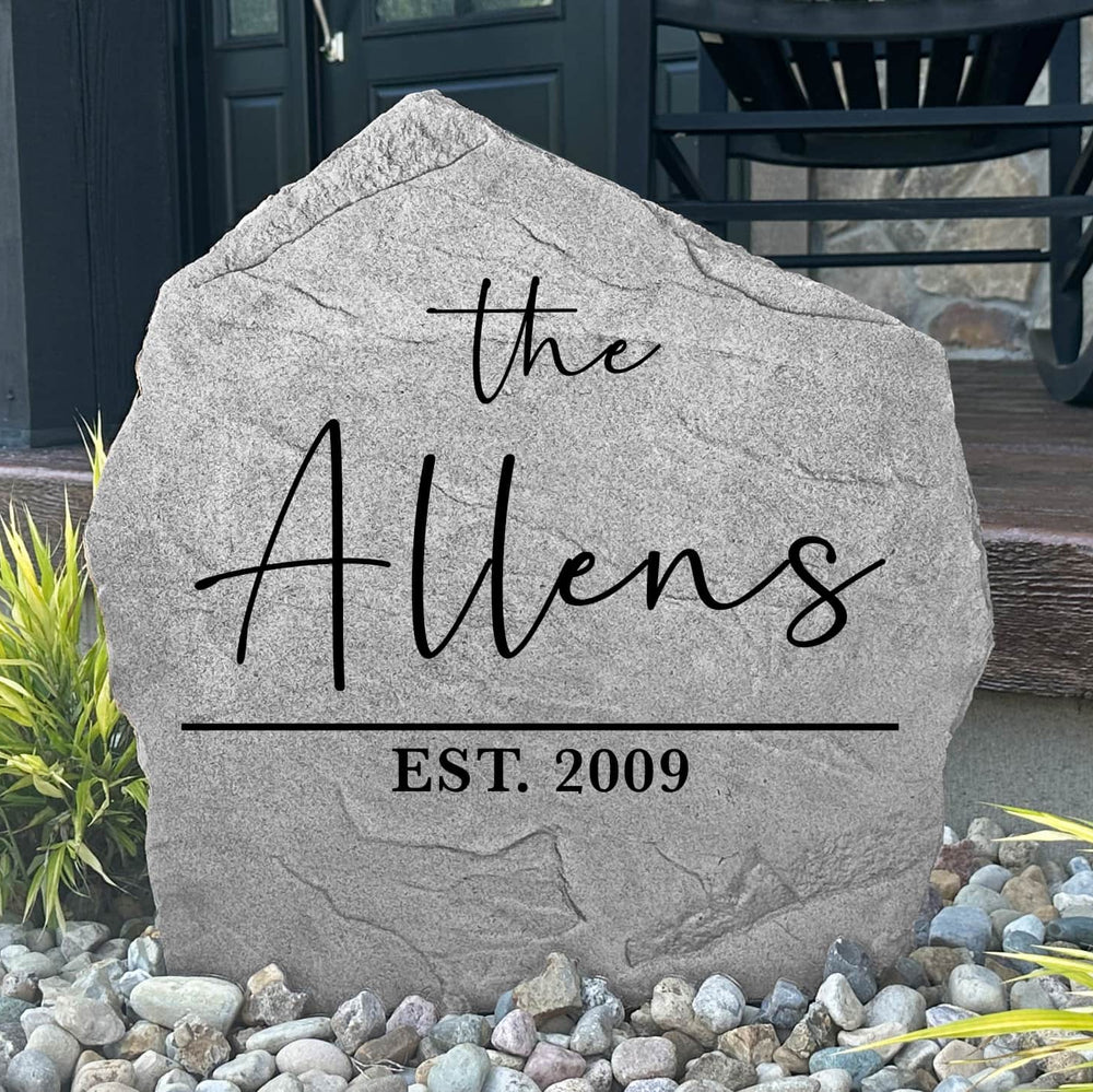 Custom Modern Name Stone displayed in a landscaped flower bed, showcasing clean lines and permanent engraving. This personalized family name stone creates a sophisticated focal point for walkways, porches, and outdoor living spaces.