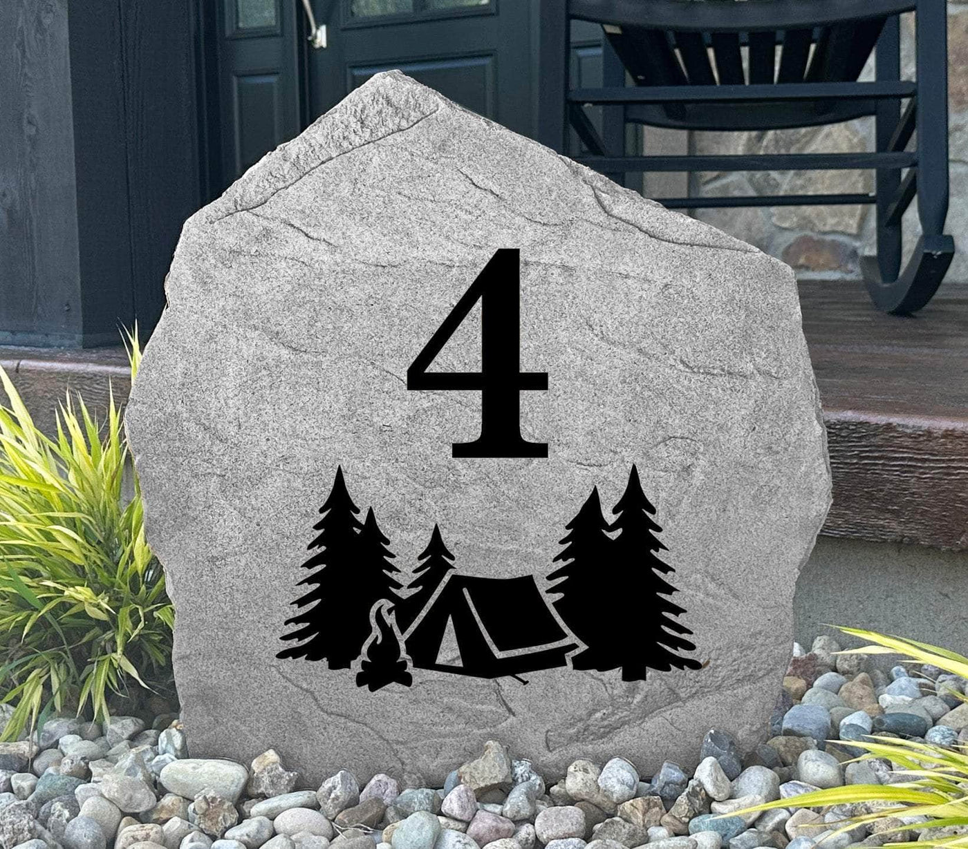 Engraved campsite rock marker featuring camping scene with trees and campfire