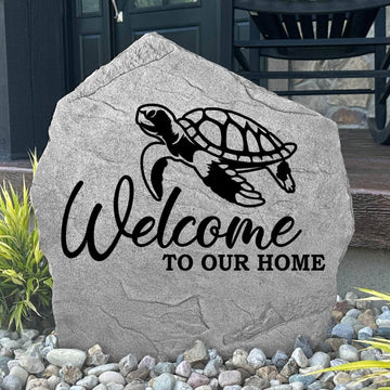 Custom Welcome Sea Turtle Stone displayed in a landscaped flower bed, showcasing detailed sea turtle artwork and a warm welcome message. This engraved outdoor stone creates a beautiful focal point for walkways and coastal-inspired landscapes.