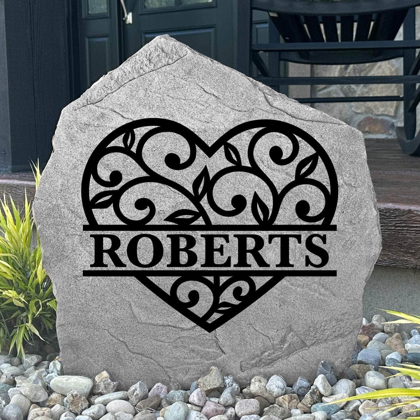 Custom Heart Monogram Stone displayed in a landscaped flower bed, showcasing personalized engraving and romantic heart accents. This engraved outdoor stone creates a beautiful focal point for walkways and home entrances.