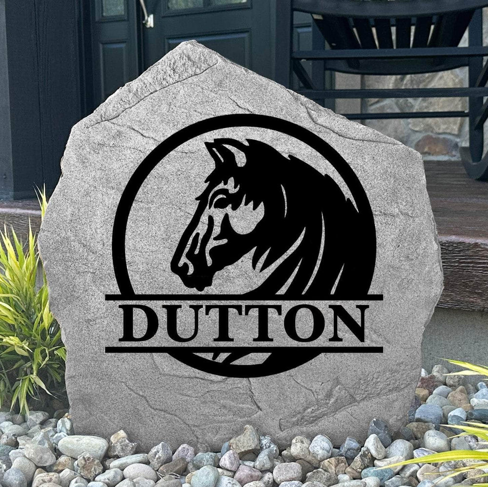 Custom Horse Monogram Name Stone displayed in a landscaped flower bed, showcasing personalized family lettering and detailed horse artwork. This engraved outdoor stone creates a beautiful focal point for horse lovers and country homes.