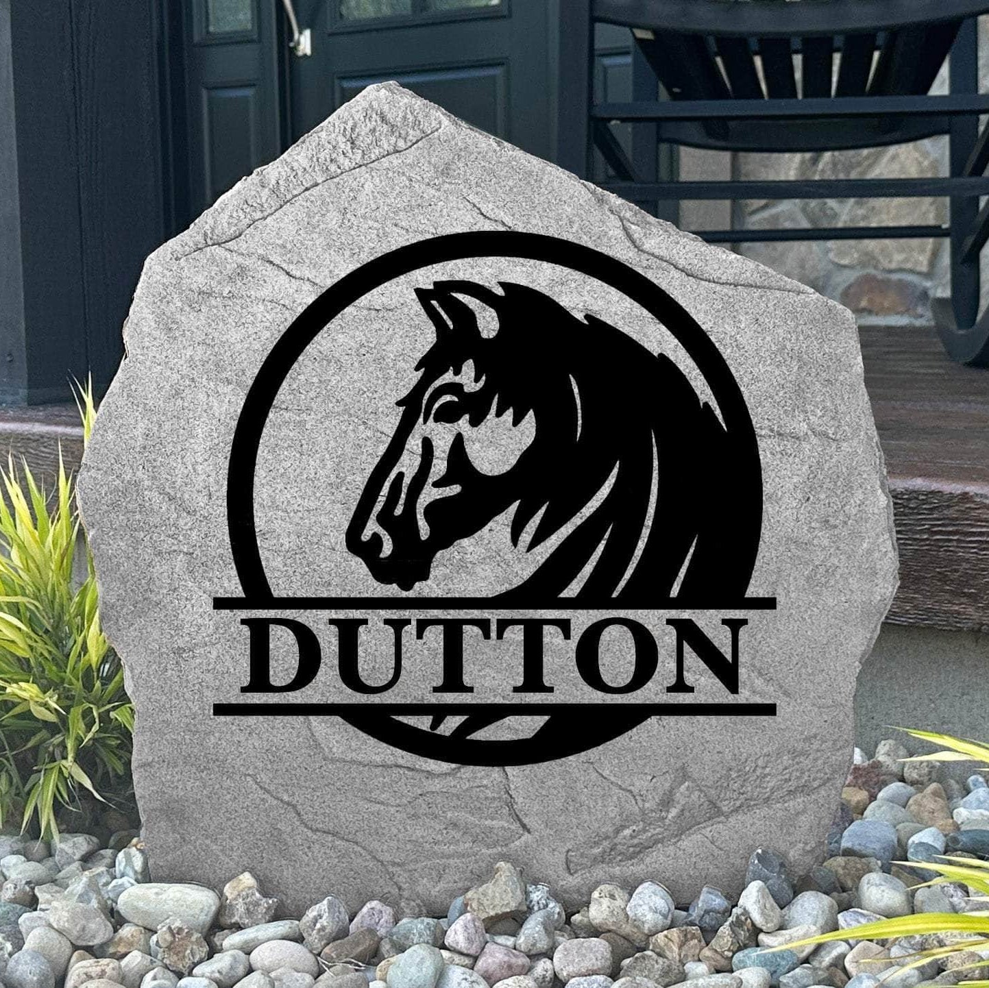 Custom Horse Monogram Name Stone displayed in a landscaped flower bed, showcasing personalized family lettering and detailed horse artwork. This engraved outdoor stone creates a beautiful focal point for horse lovers and country homes.