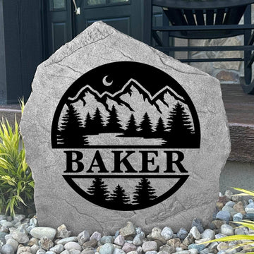 Custom Forest Monogram Stone displayed in a landscaped flower bed, showcasing personalized engraving and nature-inspired forest details. This engraved outdoor stone creates a beautiful focal point for gardens, walkways, and cabin entrances.