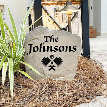Engraved Pickleball Name Stone nestled among colorful flowers and greenery, combining custom family personalization with a love for the game. This weather-resistant decorative stone brings charm and style to patios, walkways, and landscape beds