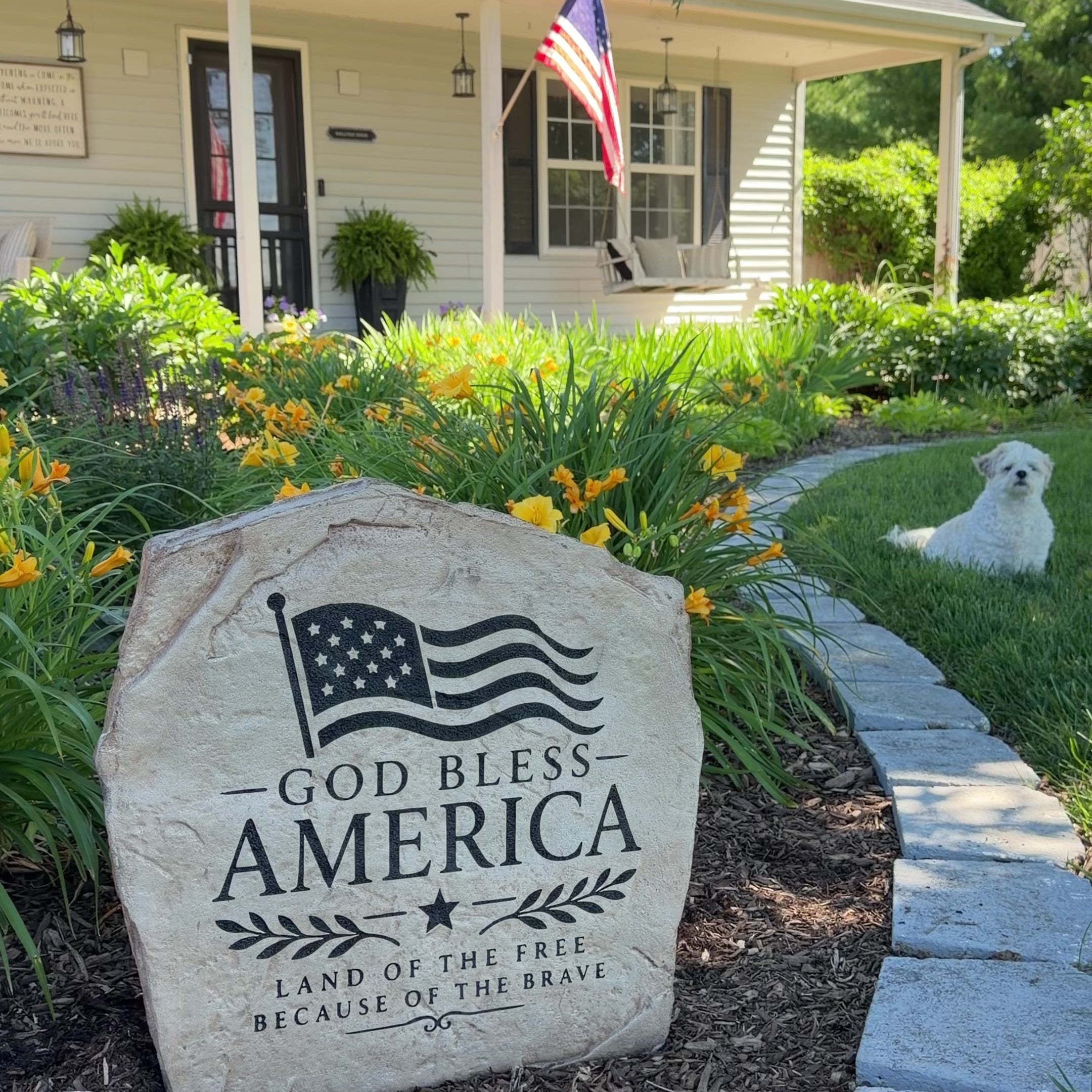 Nestled among colorful flowers and natural stone, the God Bless America Flag Stone proudly displays a beautifully engraved American flag and patriotic message. Its timeless design creates a striking focal point that celebrates faith, freedom, and love of country while adding meaningful character to the landscape.
