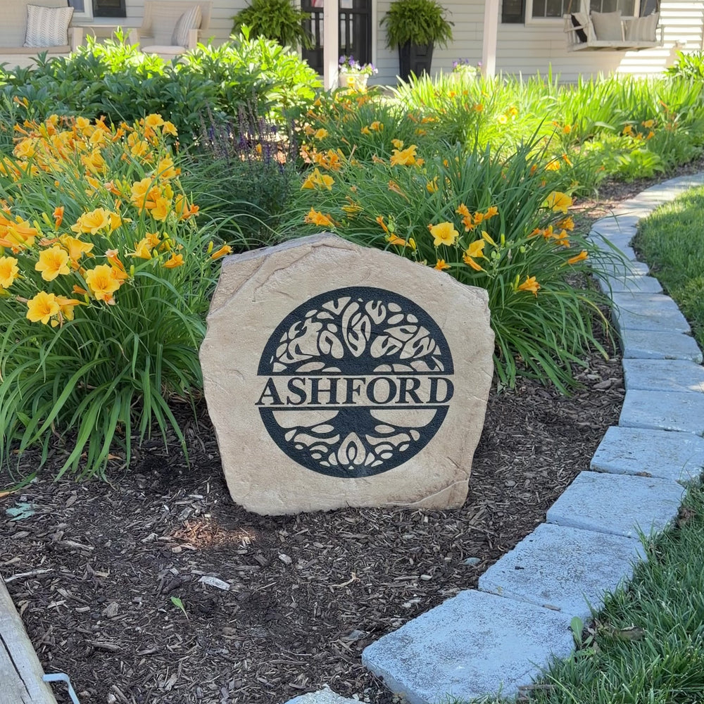 Gracefully nestled among flowers and greenery, the Tree of Life Monogram Stone showcases a personalized initial surrounded by an intricate tree design symbolizing family, strength, and growth. Its elegant engraving and timeless style create a meaningful focal point that enhances the beauty of any garden, entryway, or landscape.