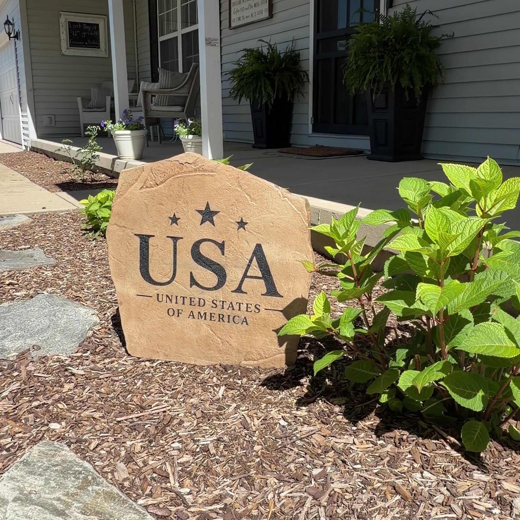 Set against a backdrop of vibrant landscaping, the American Pride Stone makes a bold statement with its clean engraved design celebrating the USA. Its classic styling and patriotic spirit create a striking accent that brings pride and timeless beauty to a front yard, garden, or walkway.