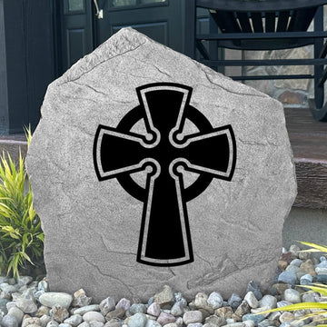 Decorative Celtic Cross Stone displayed in a landscaped flower bed, showcasing intricate Celtic artwork and lasting craftsmanship. This outdoor stone creates a peaceful focal point for walkways, gardens, and entryways.