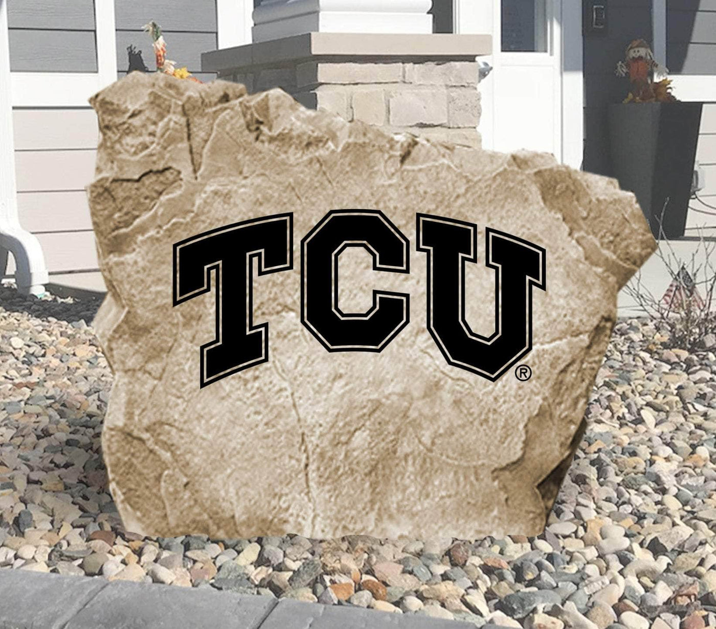 Texas Christian University engraved logo stone displayed in landscaped yard