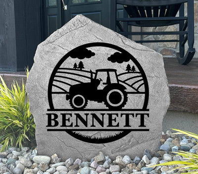 Engraved outdoor rock with custom name and tractor scene, perfect for farm families.
