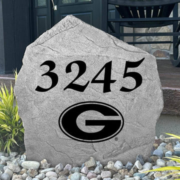 Custom University of Georgia Address Stone displayed in a landscaped flower bed with personalized house numbers and officially licensed Georgia Bulldogs artwork. This engraved address marker creates a striking focal point for alumni homes and devoted Bulldogs fans.