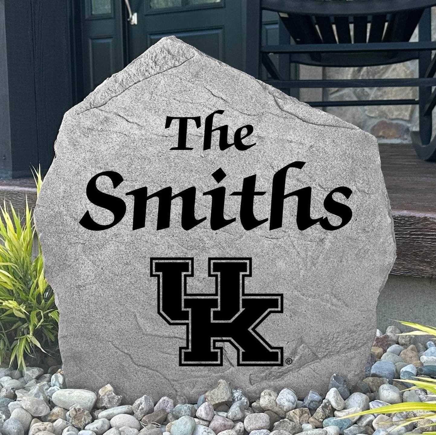 Custom University of Kentucky Name Stone displayed in a landscaped flower bed, showcasing personalized family lettering and officially licensed Kentucky Wildcats artwork. This decorative outdoor stone creates a beautiful focal point for alumni homes and Wildcats fans.