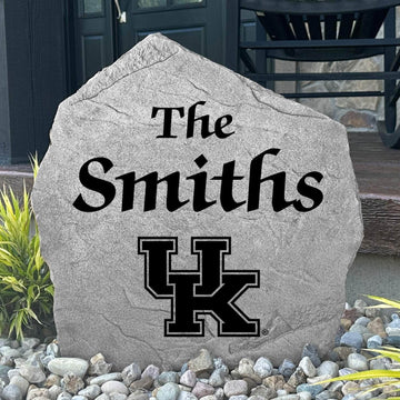 Custom University of Kentucky Name Stone displayed in a landscaped flower bed, showcasing personalized family lettering and officially licensed Kentucky Wildcats artwork. This decorative outdoor stone creates a beautiful focal point for alumni homes and Wildcats fans.