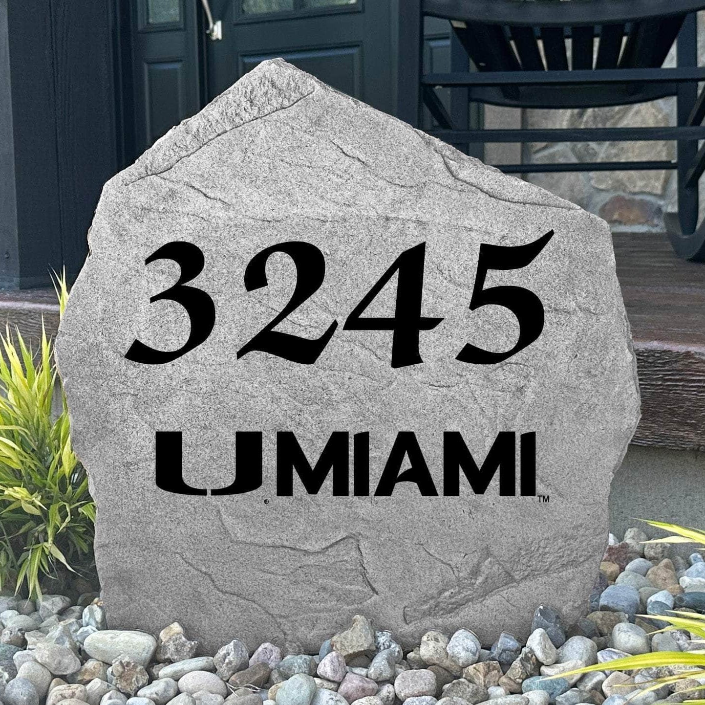 Custom University of Miami Address Stone displayed in a landscaped flower bed, showcasing personalized house numbers and officially licensed Miami Hurricanes artwork. This engraved address stone creates a beautiful focal point for alumni homes and outdoor spaces.