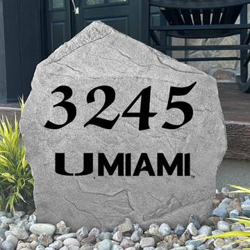 Custom University of Miami Address Stone displayed in a landscaped flower bed, showcasing personalized house numbers and officially licensed Miami Hurricanes artwork. This engraved address stone creates a beautiful focal point for alumni homes and outdoor spaces.