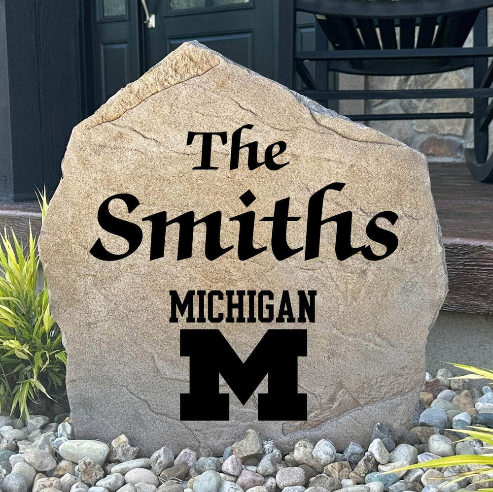 Officially licensed University of Michigan Name Stone featuring a personalized family name and the iconic Michigan Wolverines logo engraved directly into the stone surface. This custom garden stone adds school pride and curb appeal to front yards, patios, gardens, and entryways.
