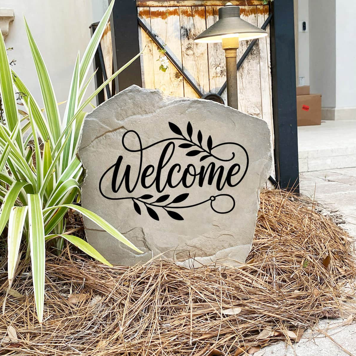 Engraved Welcome Stone nestled among colorful flowers and greenery, providing a charming focal point for walkways and front porches. This weather-resistant garden stone brings lasting style and inviting curb appeal to the home.