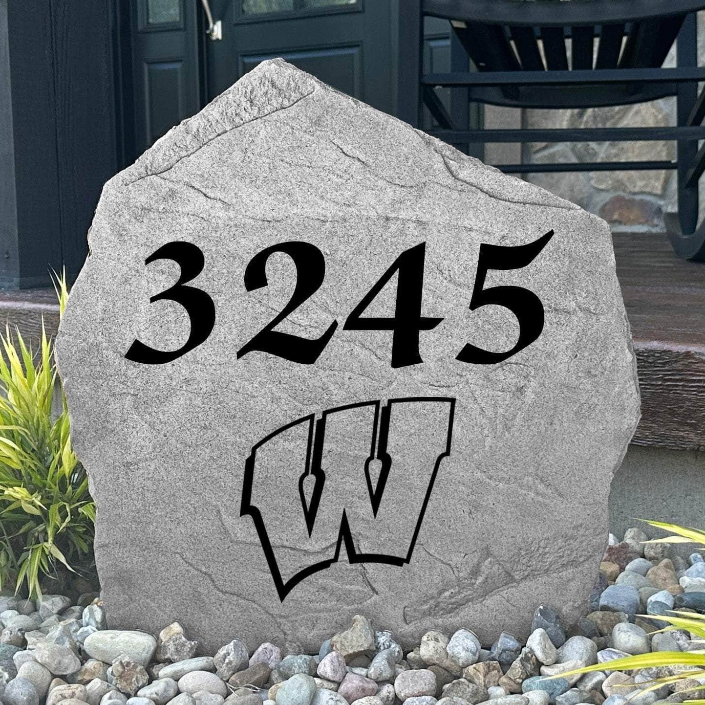Custom University of Wisconsin Address Stone displayed in a landscaped flower bed, showcasing personalized house numbers and officially licensed Wisconsin Badgers artwork. This engraved address stone creates a beautiful focal point for alumni homes and outdoor spaces.