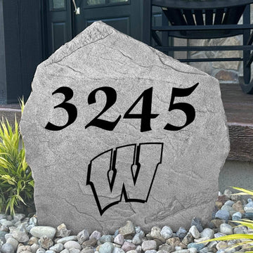 Custom University of Wisconsin Address Stone displayed in a landscaped flower bed, showcasing personalized house numbers and officially licensed Wisconsin Badgers artwork. This engraved address stone creates a beautiful focal point for alumni homes and outdoor spaces.